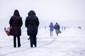 Berliners walk across Tempelhofer Feld in Berlin during snowfall