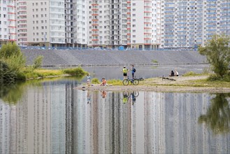Local Russians relaxing on riverbank of the Yenisei River and newly built flats