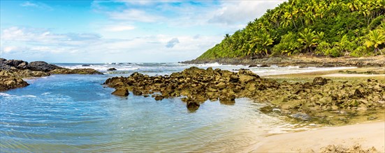 Sea between vegetation and rocks at Prainha beach in Serra Grande on the south coast of Bahia
