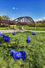 Blue sheep in front of old railway bridge
