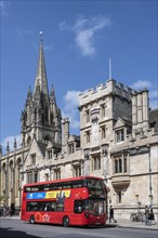 Double decker bus in front of All Souls College on the right and St Mary's Church on the left on the High Street in the Old Town of Oxford