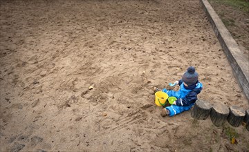 Child sitting alone in a playground.