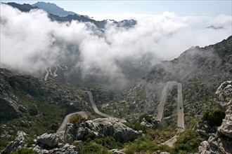 The winding road from Sa Calobra to Coll dels Reis in the Tramuntana Mountains with clouds