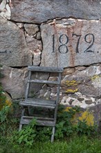 Year on old wall and old wooden chair