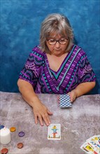 Older white haired woman pythoness casting tarot cards