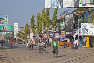 Cyclists and motorbike riders in shopping street in Pyay