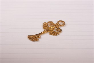 Golden color decorative key on lined sheet of paper