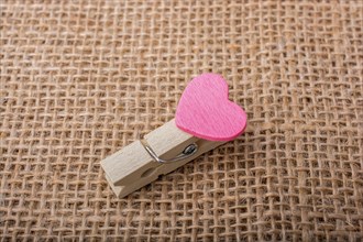 Colorful heart attached to a clothespin in hand