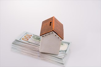 Model house placed on the American dollar banknotes on white background