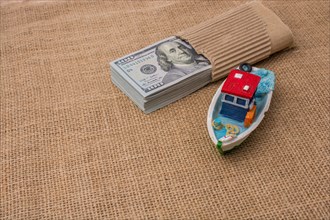 Model boat and banknote bundle of US dollar on canvas
