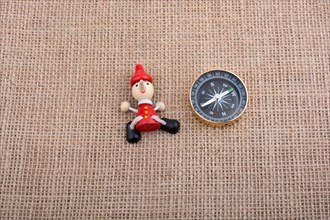 Figurine of pinocchio by the side of a compass