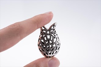 Hand holding a tulip model on a white background