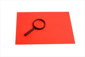 Magnifying glass on a sheet of paper on white background