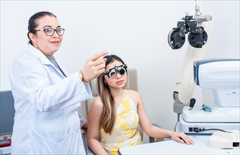 Optometrist assisting patient with optometrist trial frame. Patient with optometrist in a vision test with trial frame