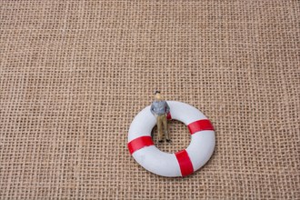 Little figurine man in a life preserver on life on canvas