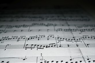 Close-up of sheet music with blurred black background