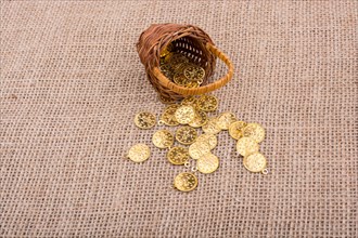 Fake gold coins out of a little basket on canvas