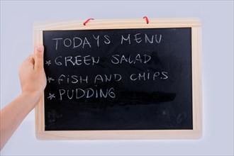 Hand holding the board with the menu of the day written with chalk