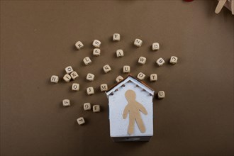 Wooden letter cubes and man figurine and model house
