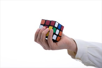 Child holding a Rubik's cube in hand on a white background