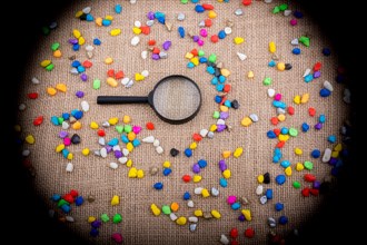 Magnifying glass amid Colorful pebbles