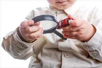 Baby holding a magnifying glass in hand on a white background
