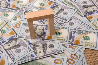 Wooden building blocks placed on spread US dollar Banknotes