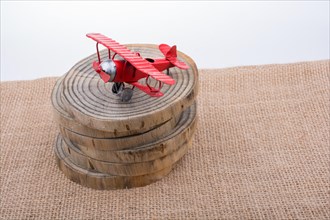Red color toy plane is on a wooden texture