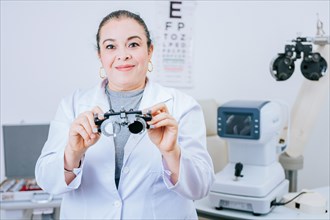 Portrait of optometrist holding messbrille lens in laboratory. Optometrist specialist holding optometric trial frame