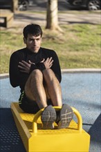 Attractive man doing sit-ups in the park