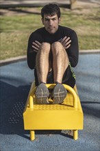 Attractive man doing sit-ups in the park