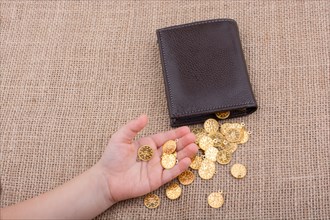 Wallet and plenty of fake gold coins in hnad