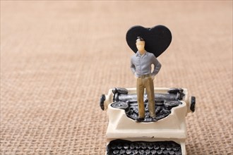 Retro syled tiny typewriter model on a canvas background