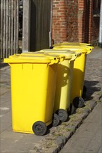 Yellow bins for plastic waste standing on the street