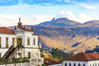 Baroque church and mountains in the city of Ouro Preto in Minas Gerais with the mountains and peak of Itacolomi in the background during sunset