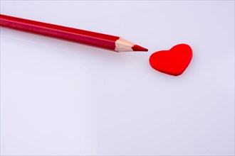 Pencil pointing a red heart
