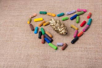 Pine cone in the middle of crayons form a heart shape
