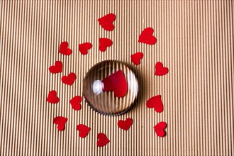 Red color paper hearts under and around half glass globe