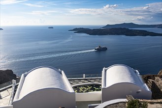 Ferry bypassing a luxury hotel on the calderea of Fira