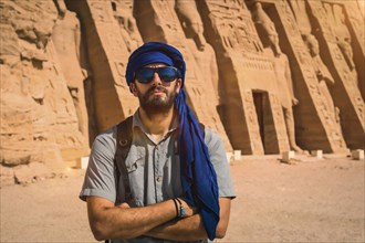 A young man wearing a blue turban visiting the Egyptian Temple of Nefertari near Abu Simbel in southern Egypt in Nubia next to Lake Nasser. Temple of Pharaoh Ramses II