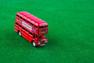 Red london bus on green grass