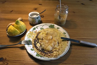 Pancakes with apple sauce and lemon on a plate
