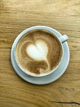 Cup of cappuccino with milk foam in the shape of a heart