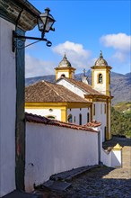 Side view of an old colorful baroque church with the mountains in the background in the city of Ouro Preto in Minas Gerais