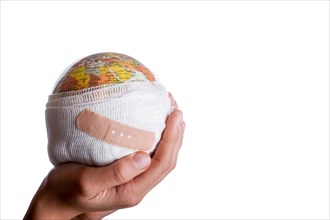 Child holding a globe with plaster in his hand on a white background