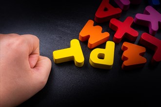 Hand and Colorful Letters of Alphabet made of wood