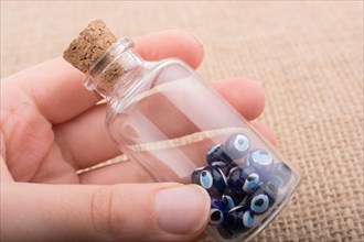 Hand holding Evil eye bead in bottle as souvenir