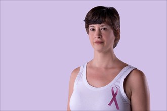 Portrait of woman in a white T-shirt with a pink ribbon