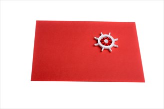 Isolated steering wheel on a red sheet of paper