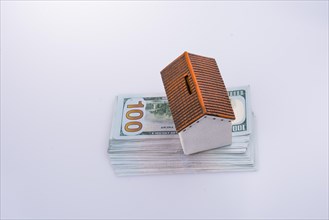 Model house placed on the American dollar banknotes on white background